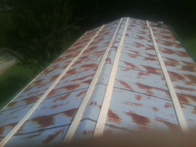 Rusted metal roof panels with new wood purlins before replacement — Storm Damage Roof Repair in Newsoms by Roofing Brothers