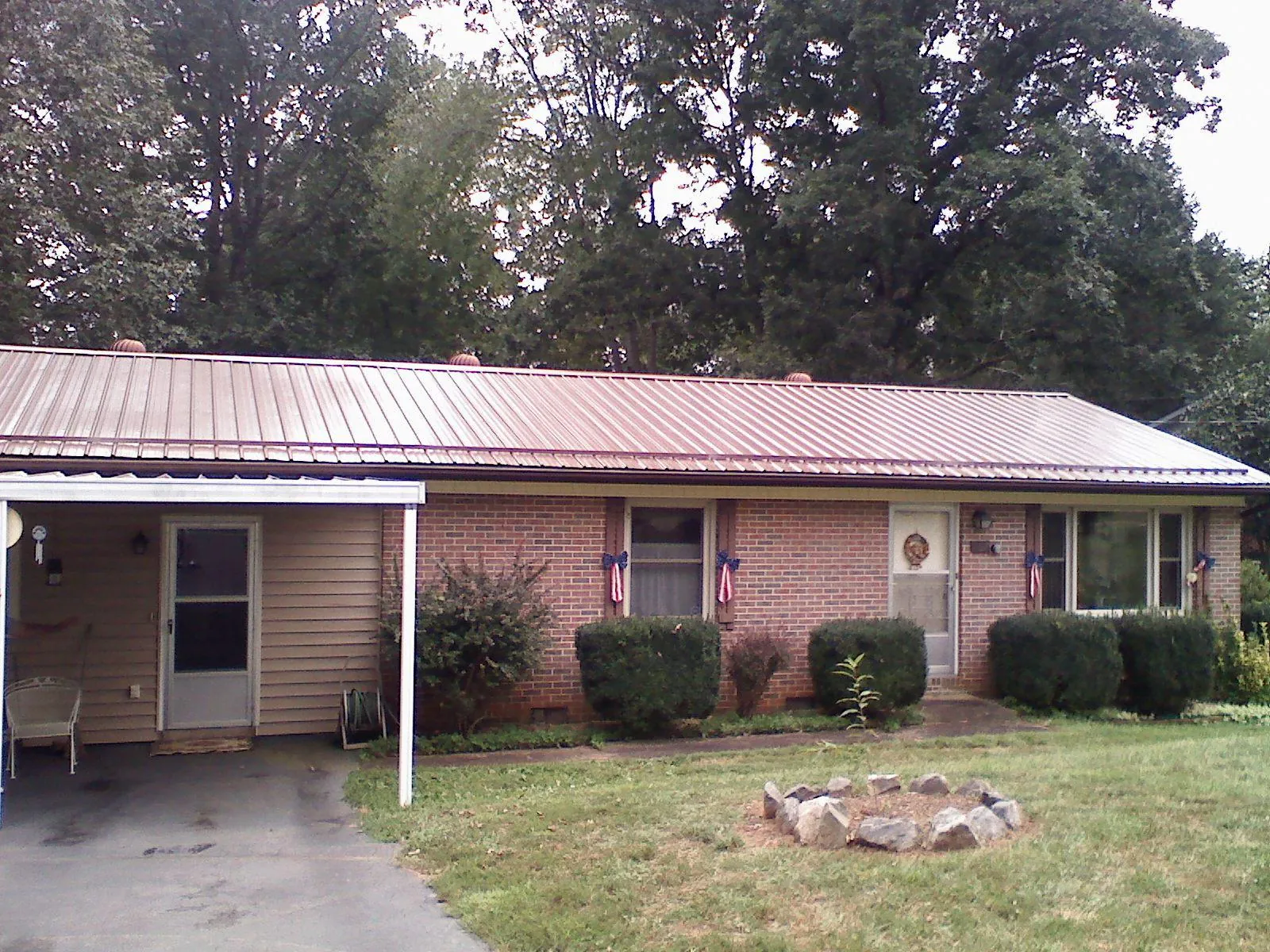 Bronze metal roof and carport on a brick ranch home — Roof Repair work by our crew in Newsoms