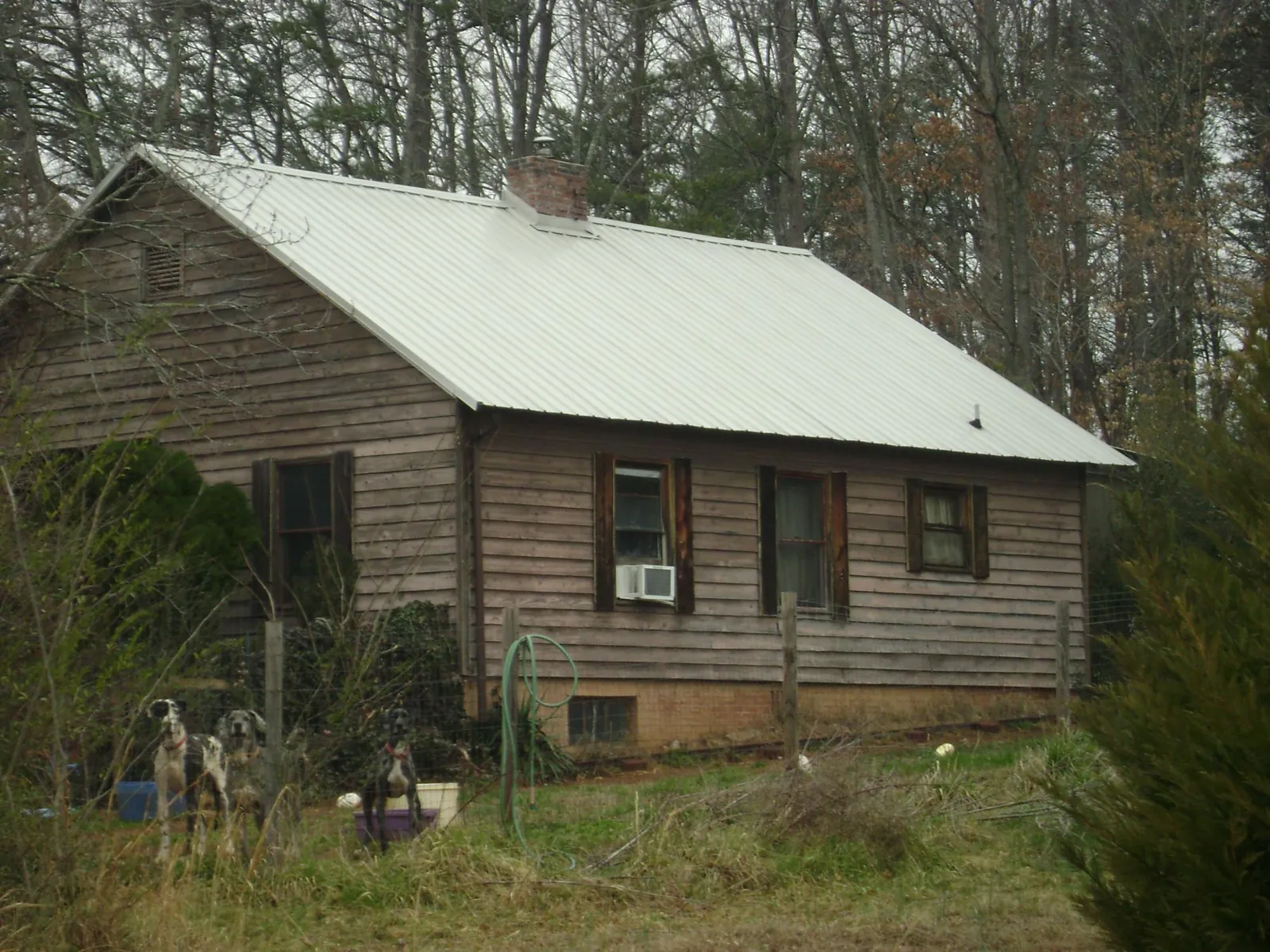 White metal roof on an old wood sided farmhouse, from a Metal Roof Installation job in Newsoms